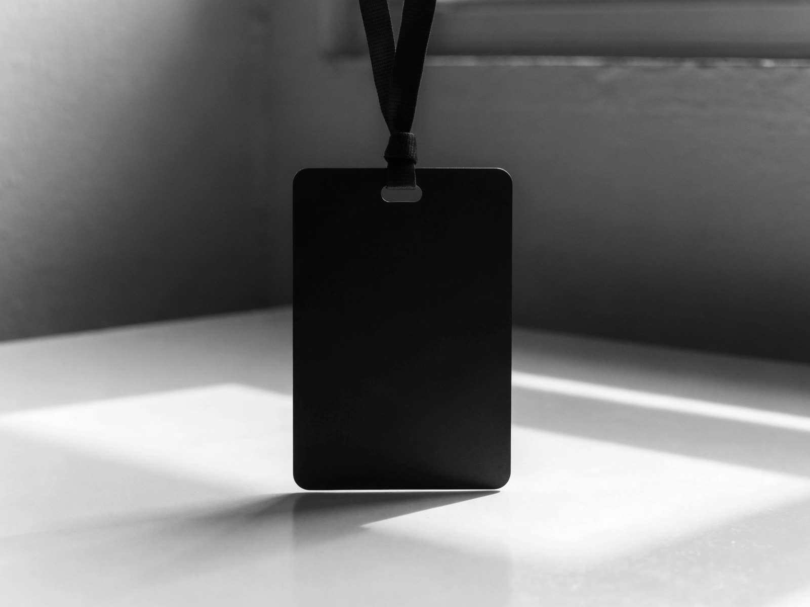 Crachá preto com o símbolo branco e o nome Vitor Nader