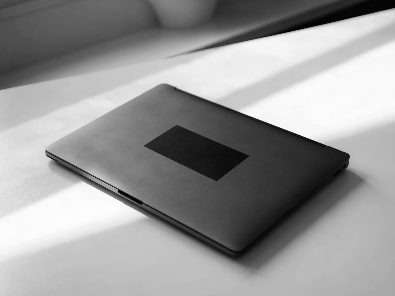 Notebook fechado com adesivo preto do símbolo branco
