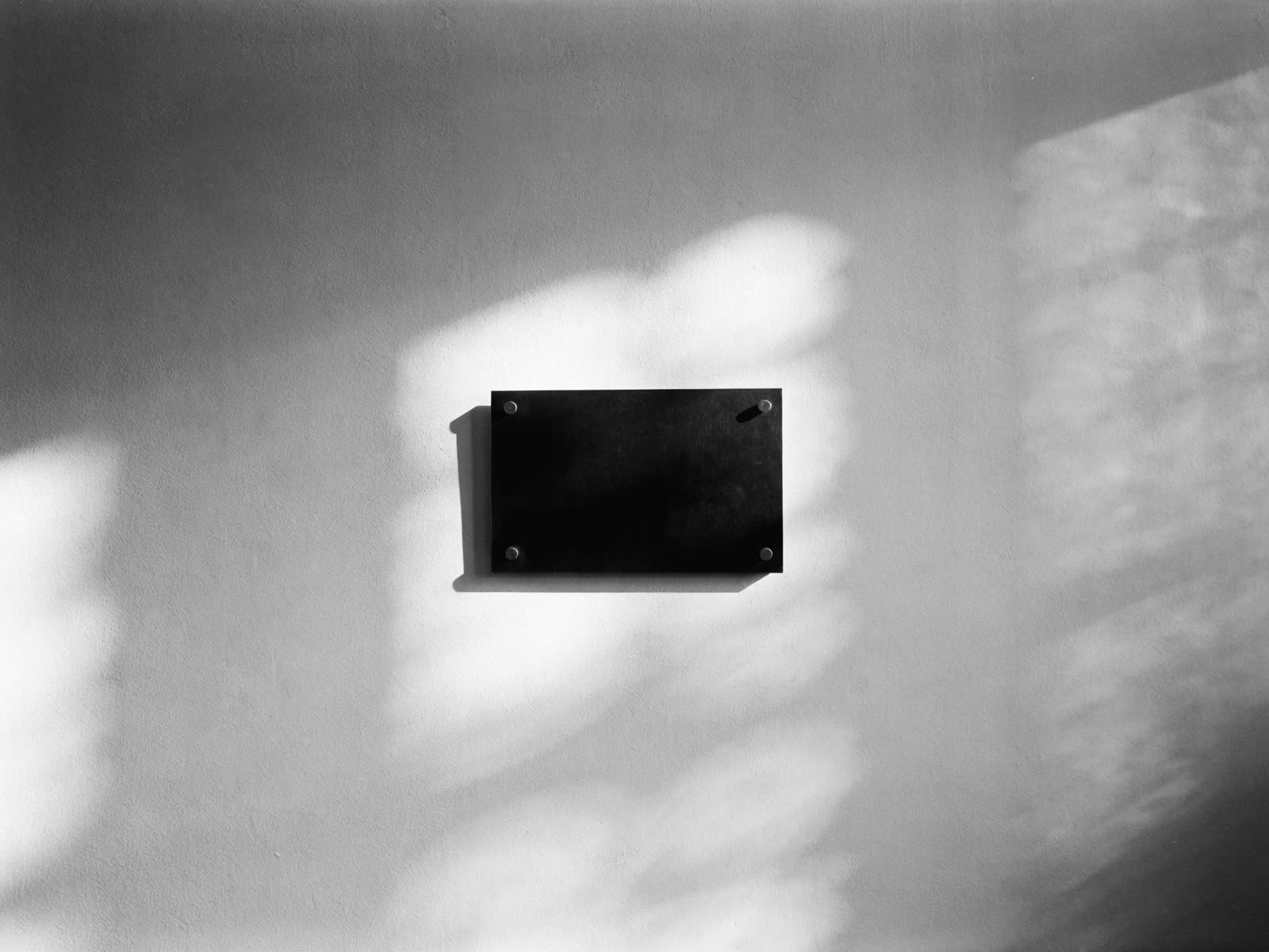Placa preta na parede com a assinatura horizontal branca